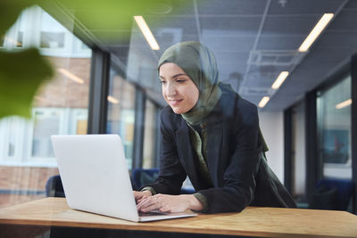 Woman in office using laptop