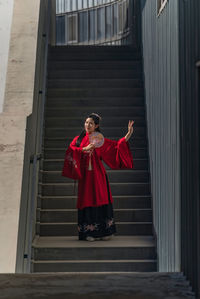 Portrait of woman standing against wall