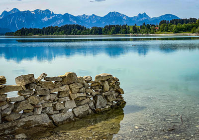 Scenic view of lake by mountains against sky