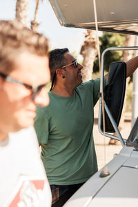 Two skateboarder friends chatting near their camper van in gran ganaria