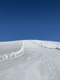 Snow covered mountain against clear blue sky