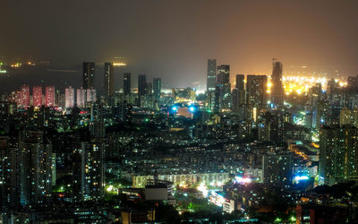 Illuminated buildings in city against sky at night