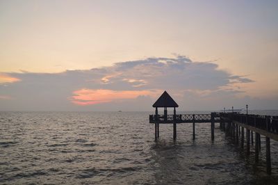 Pier over sea against sky during sunset