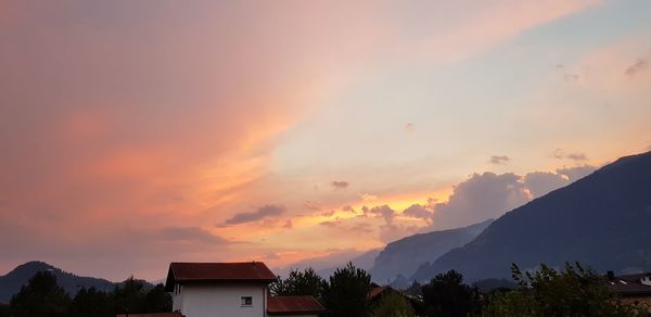 Silhouette trees and buildings against sky during sunset