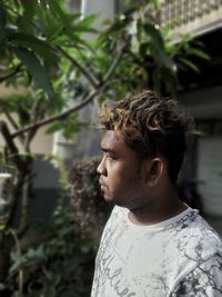 Portrait of young man looking away outdoors