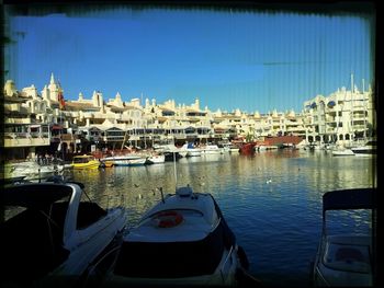 Boats in harbor with buildings in background