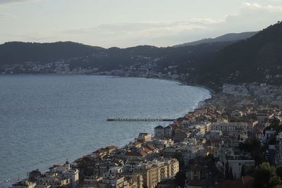 High angle view of city by sea against sky