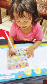 Full length of cute girl playing at table