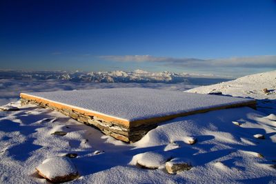 Scenic view of snow covered field against blue sky