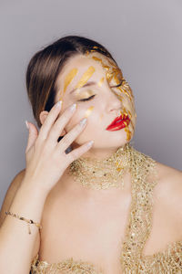 Close-up of young female model with make-up against gray background