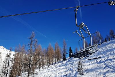 Snow covered land against clear blue sky