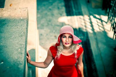 Portrait of smiling young woman standing on footpath