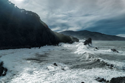 Scenic view of sea and mountains against sky