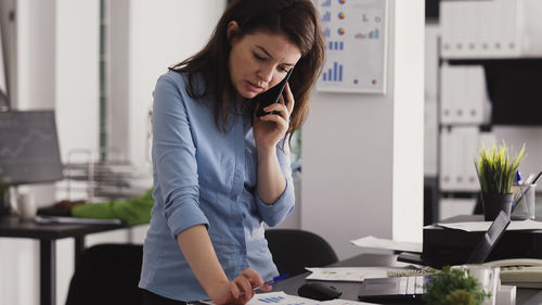 Young woman using mobile phone in cafe