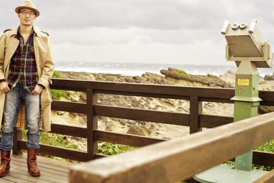 Rear view of woman standing by railing