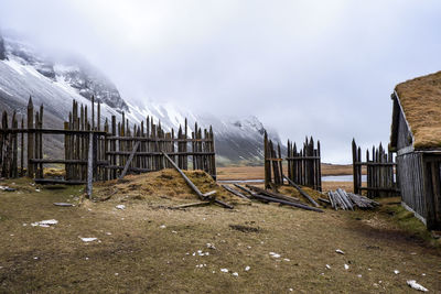 Fence on snowcapped mountain against sky