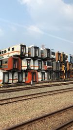 Railroad tracks by buildings in city against sky