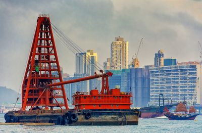 Construction site by sea against sky