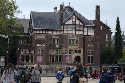 People on street against buildings in city