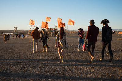 Rear view of people walking on road