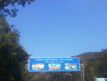 Low angle view of information sign against clear blue sky