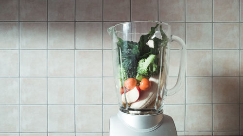 Close-up of vegetables and fruits in a mixer - making smoothies