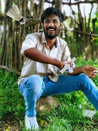 Portrait of young man sitting on field