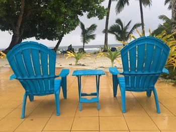 Empty chairs and table against trees