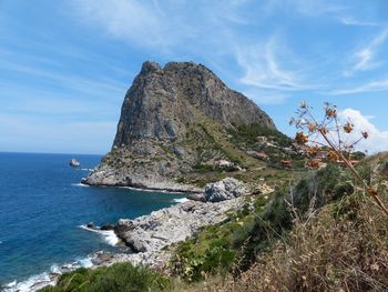 Rock formations by sea against sky