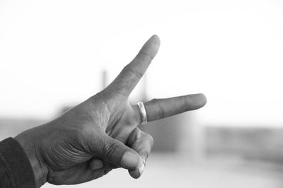 Cropped hand of man showing peace sign