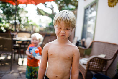 Portrait of shirtless boy standing outdoors