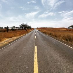 Road by landscape against sky