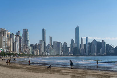 Panoramic view of beach and buildings against clear sky