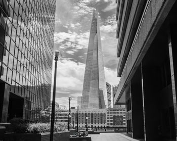 A view of the shard in london taken between two buildings. london bridge hospital is also visible.