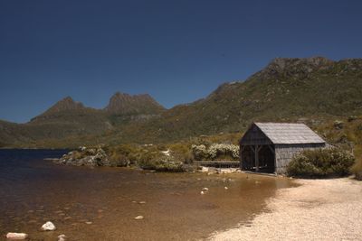 Built structure by mountains against clear sky