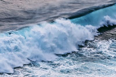 Waves splashing on sea against sky