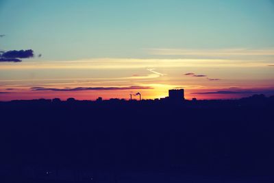 Silhouette buildings against sky during sunset