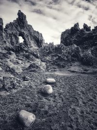 Rock formation on beach against sky