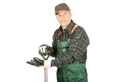 Portrait of smiling man holding umbrella against white background