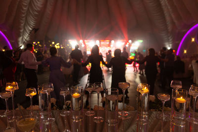 Foreground focus transparent vases decor on glass table at disco party