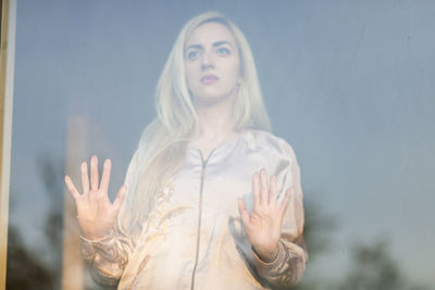 Thoughtful woman seen through glass window