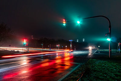 Light trails on road at foggy night