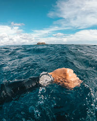 Man swimming in sea against sky