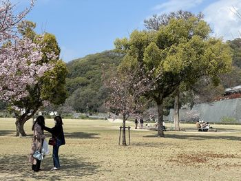 Rear view of people walking on plants