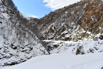 Snow covered land and mountains against sky