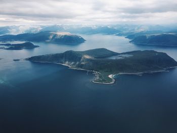 Aerial view of sea and mountains against sky