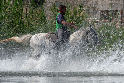 Full length of man splashing water