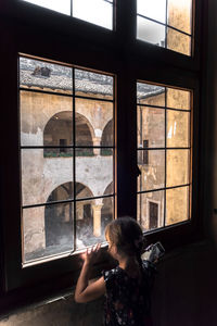 Woman photographing through window