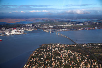 High angle view of city by sea against sky