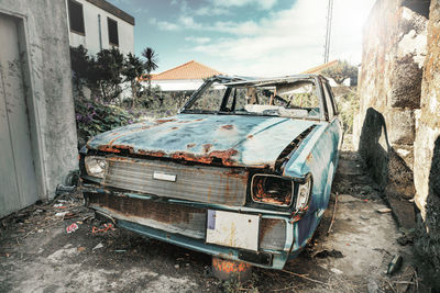 View of abandoned car against sky